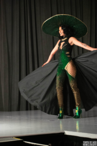 A model shows off a Loki-inspired design on the runway of the Her Universe Fashion Show. 