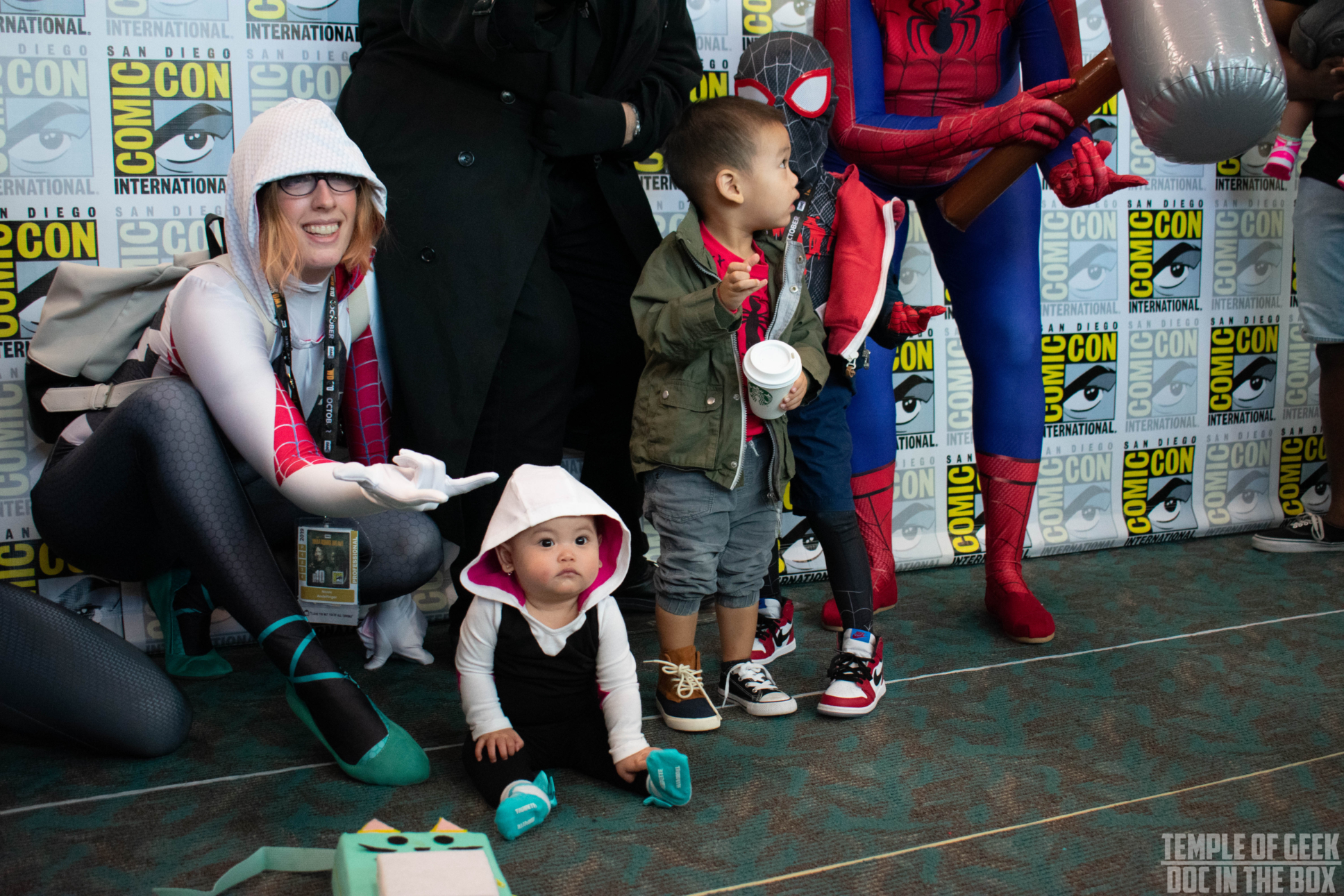 Spiderman cosplayers at San Diego Comic Con posing in front of the photo back drop.