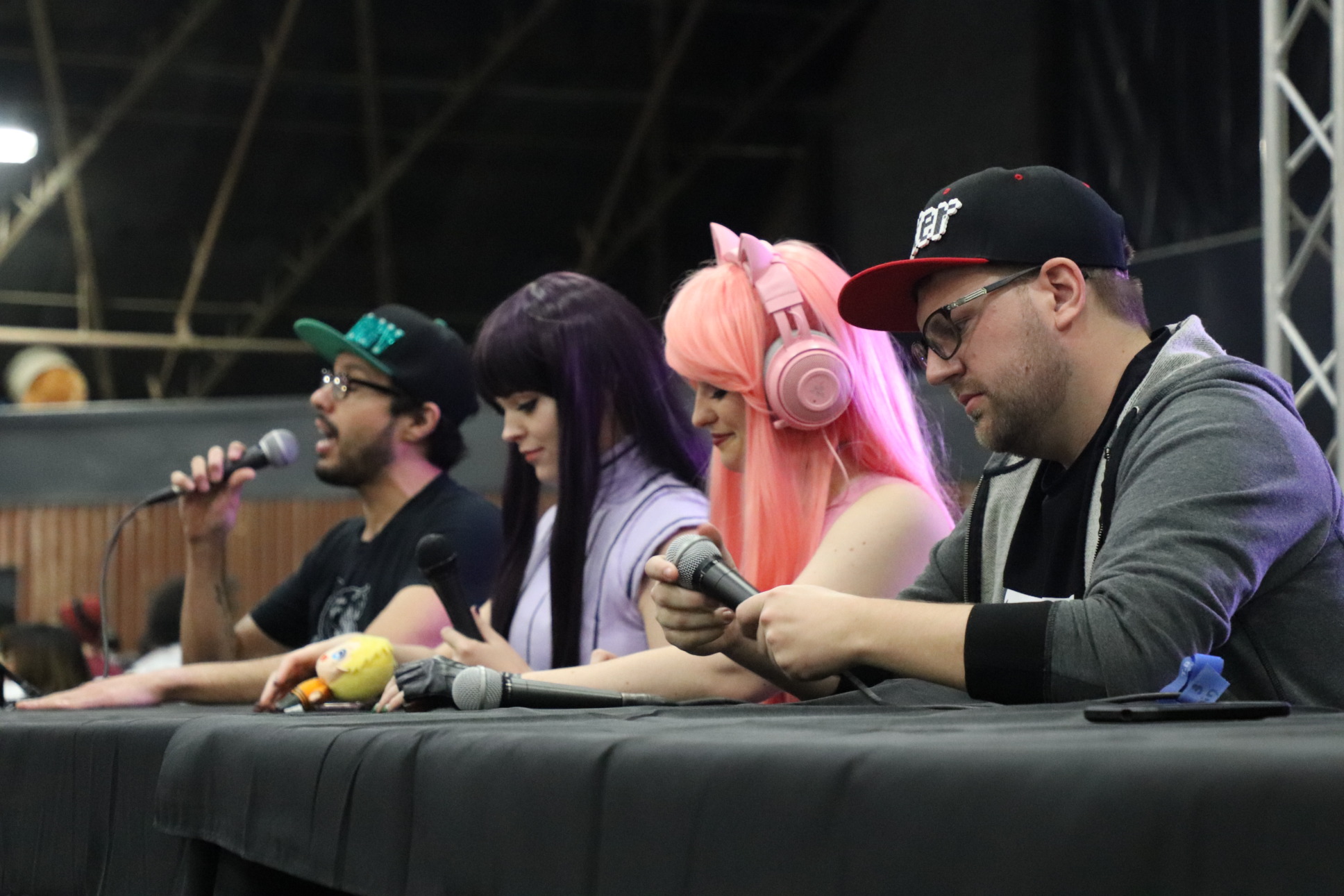 four panelist on stage, two dressed in cosplay, talking about their fandoms