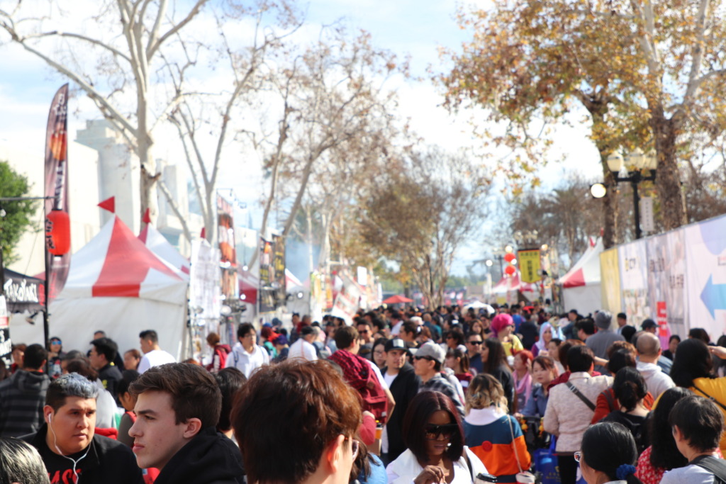 View of large crowds gathered outside near the food vendors