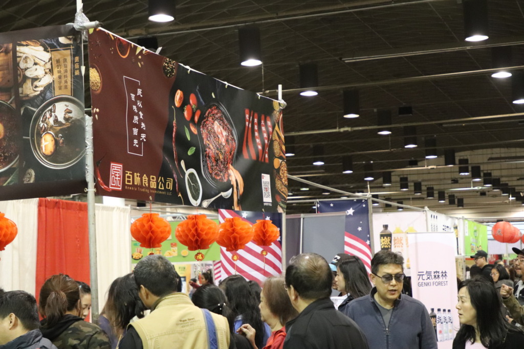 Photo of crowds around a booth where vendors are selling food