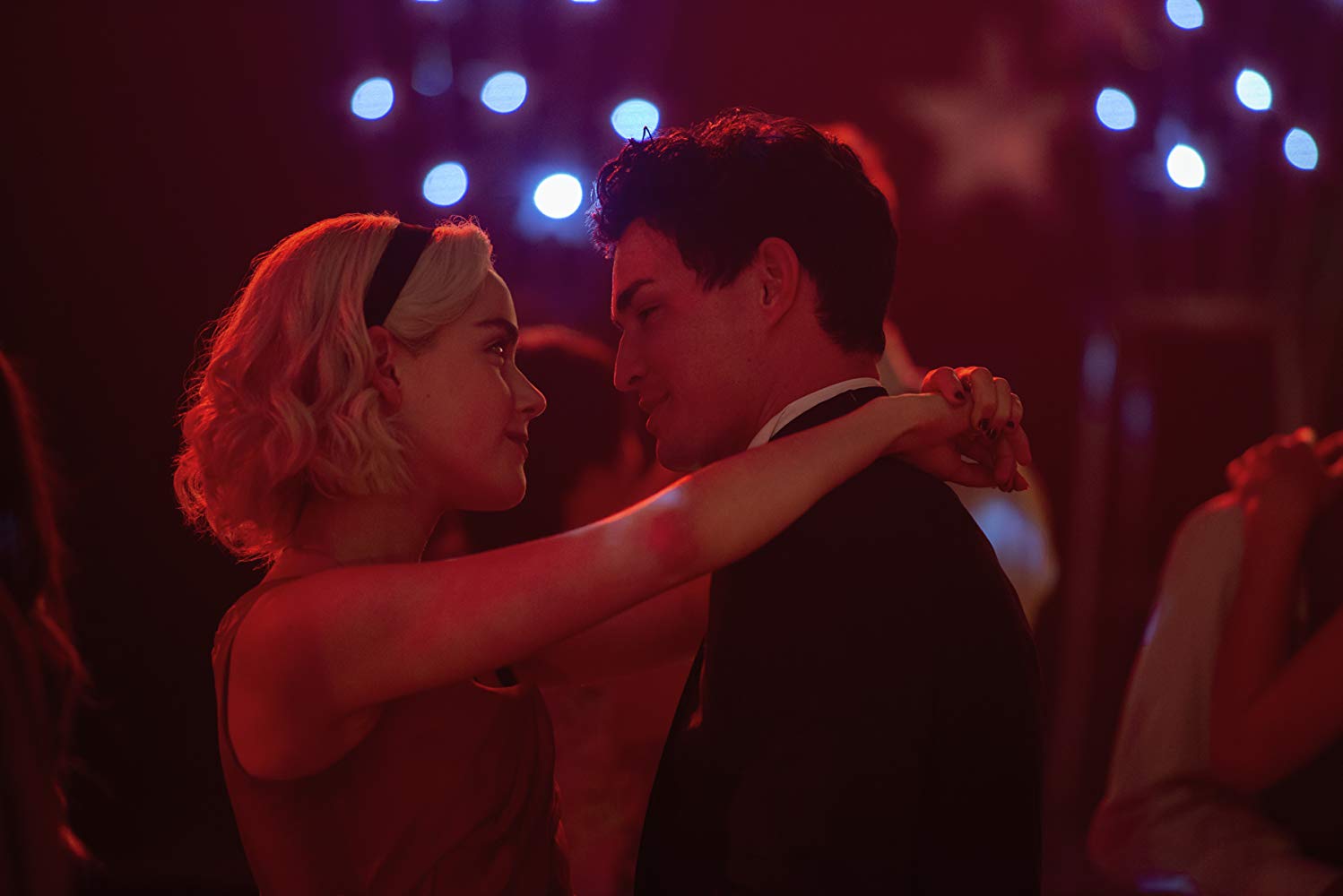 Kiernan Shipka and Gavin Leatherwood in Chilling Adventures of Sabrina (2018) They are at a school dance. dancing slowly. arms wrapped around eachothr and staring lovingly into one anothers eyes