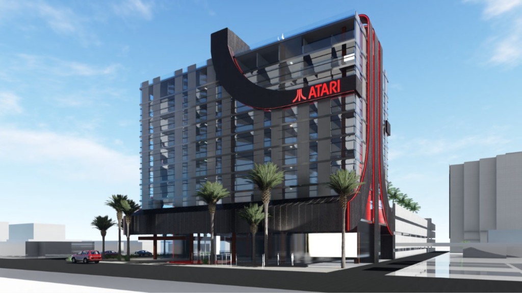 concept art of the new Atari Hotel. Image of a hotel at night. the building has part of the red artari logo built into the design. 