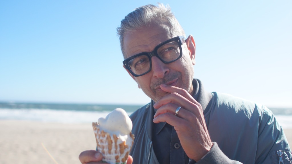 Jeff Goldblum near the beach shore eating ice cream