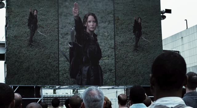 Seen on giant screen from a scene in the hunger games Katniss (Jennifer Lawrence) saluting District 11.