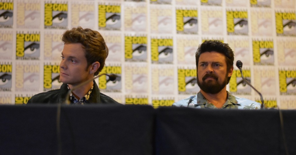 Jack Quaid (Hughie Campbell) and Karl Urban (Billy Butcher) sittingg at a panel for the Boysat San Diego Comic Con 2019