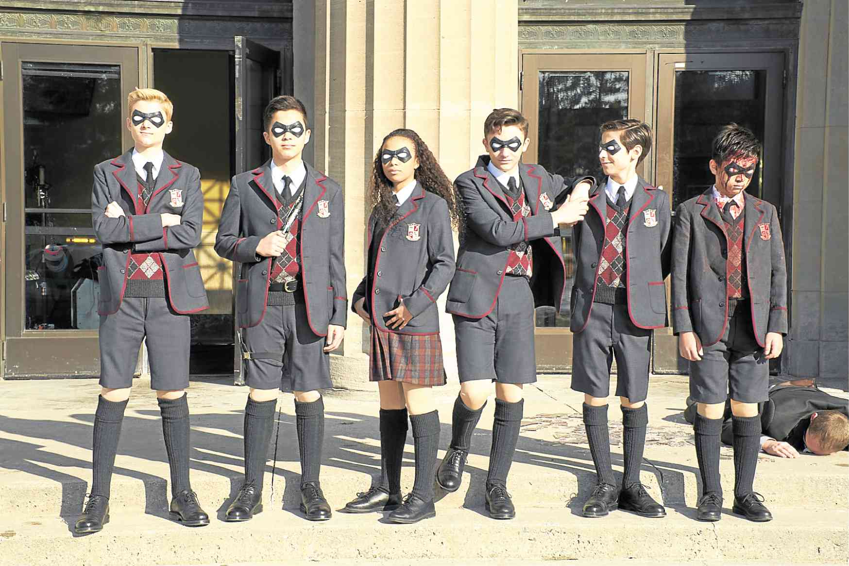 the umbrella academy kids in superhero costumes or schooluniform