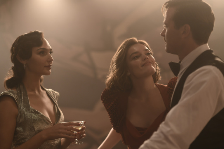 Linnette (Gadot) looks on as Jaqueline (Mackey) gazes lovingly at Simon (Hammer) 