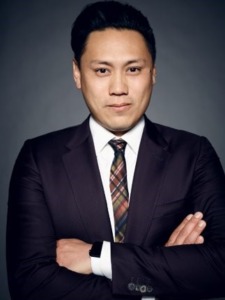 headshot photo of Jon M. Chu. Chus is wearing a suit and tie and posed with his arms crossed