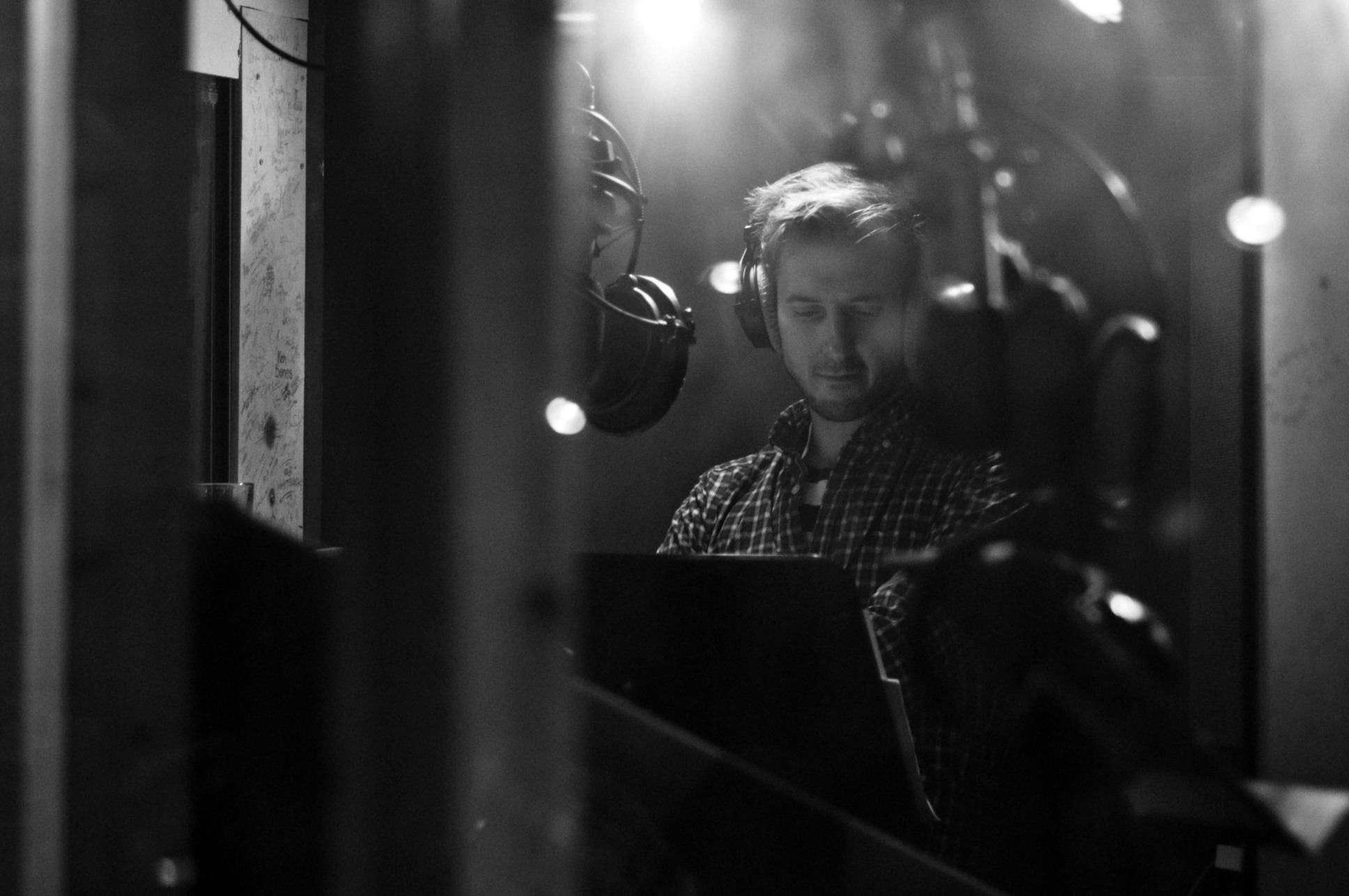 a black and white photo of Arthur Darvill in a studio recording for "The Lone Centurion"