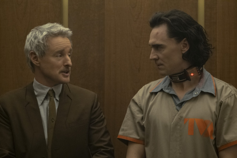 Mobius (Owen Wilson) and a handcuffed Loki (Tom Hiddleston) in a TVA prison suit talk to one another