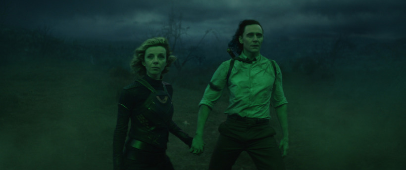 Sylvie (Sophia Di Martino) and Loki (Tom Hiddleston) hold hands as they prepare to battle Alioth in the void