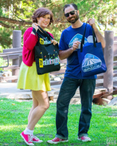 Two models show off ShimmerPop Shop's unique Disney tees and totes. 