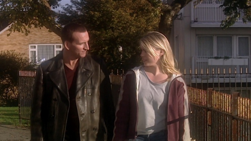 the Ninth Doctor (Christopher Eccleston) and Rose Tyler (Billie Piper) talking the morning after they first met at Rose's job. They're walking down a quiet street just a little bit away from Rose's flat with trees and other buildings in the background