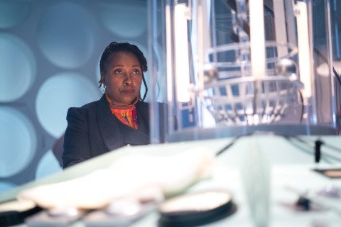 Jo Martin, as the Fugitive Doctor, stands at the console of her TARDIS