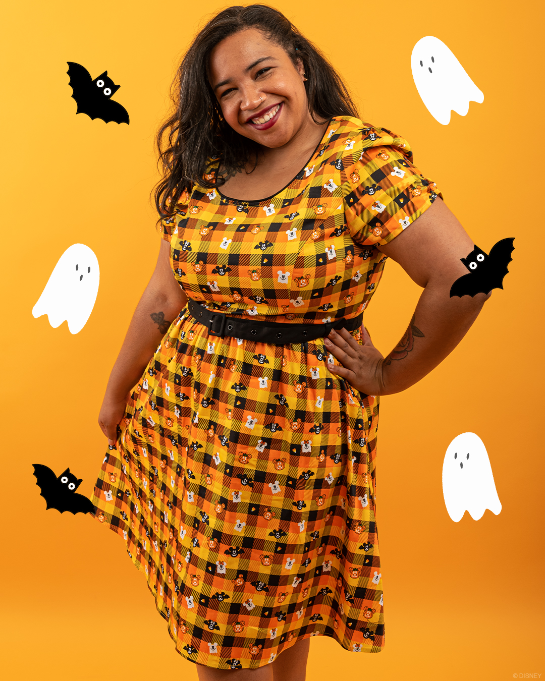 A model wears a Halloween-themed Mickey Mouse Pumpkin dress from Stitch Shoppe by Loungefly.