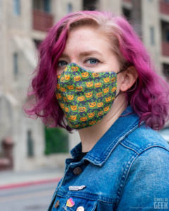 A model wears a face mask with a Halloween jack-o-lantern pattern from Fun.com.