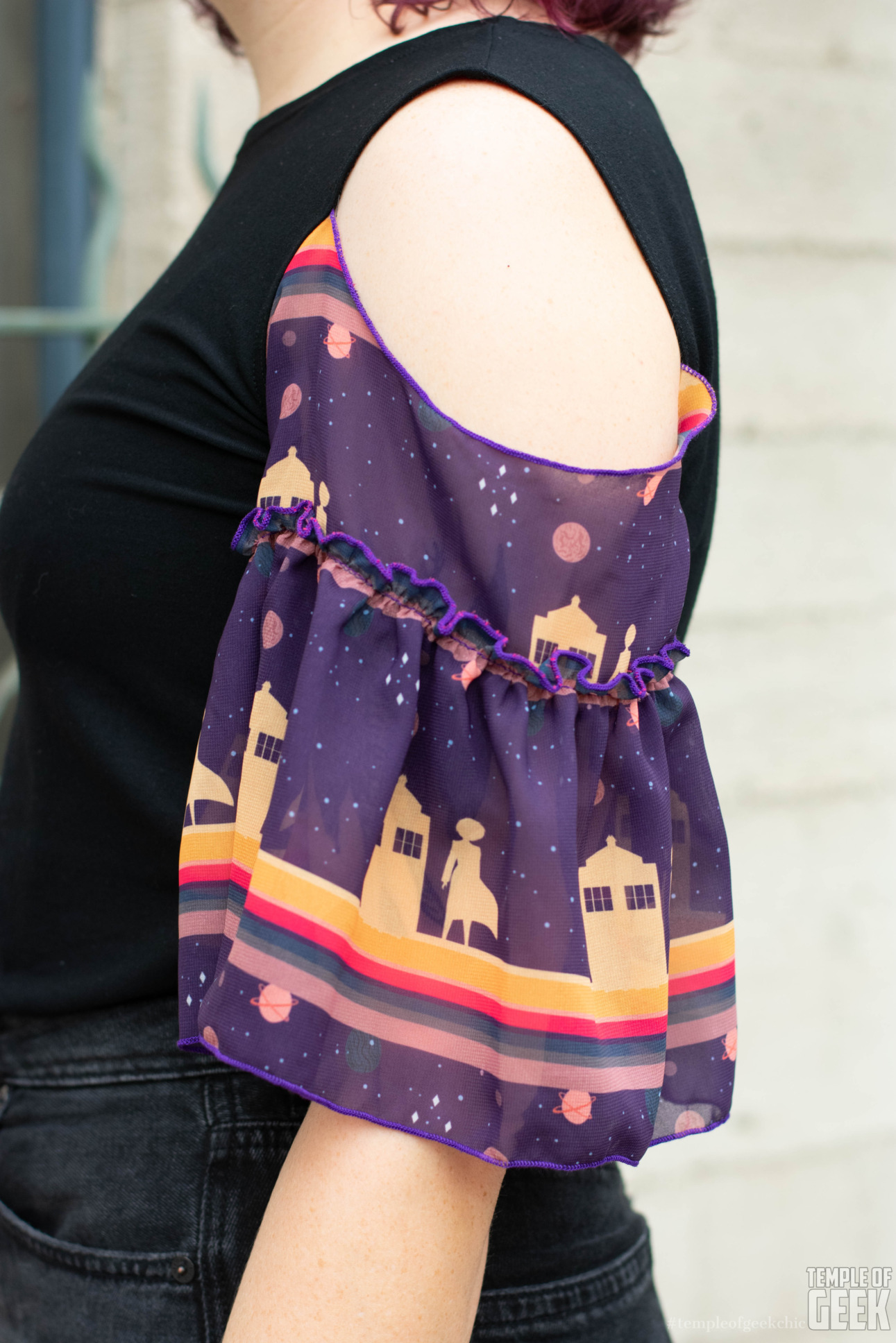 Closeup of a ruffly sleeve with a Doctor Who print from Heroicouture.