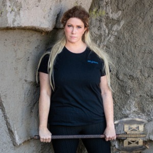 A model holds an axe and wears a black tee with the word Fighter embroidered on it by D&D fashion brand Guild Party.