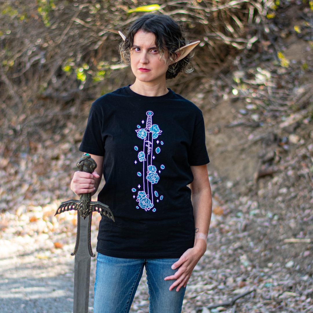 A model with elf ears and a sword wears a tee featuring a sword covered in blue flowers.