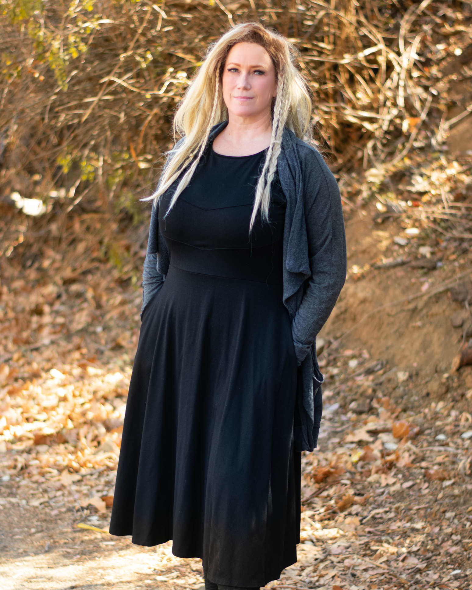 A model wears a gray cardigan over a black Longsword dress.