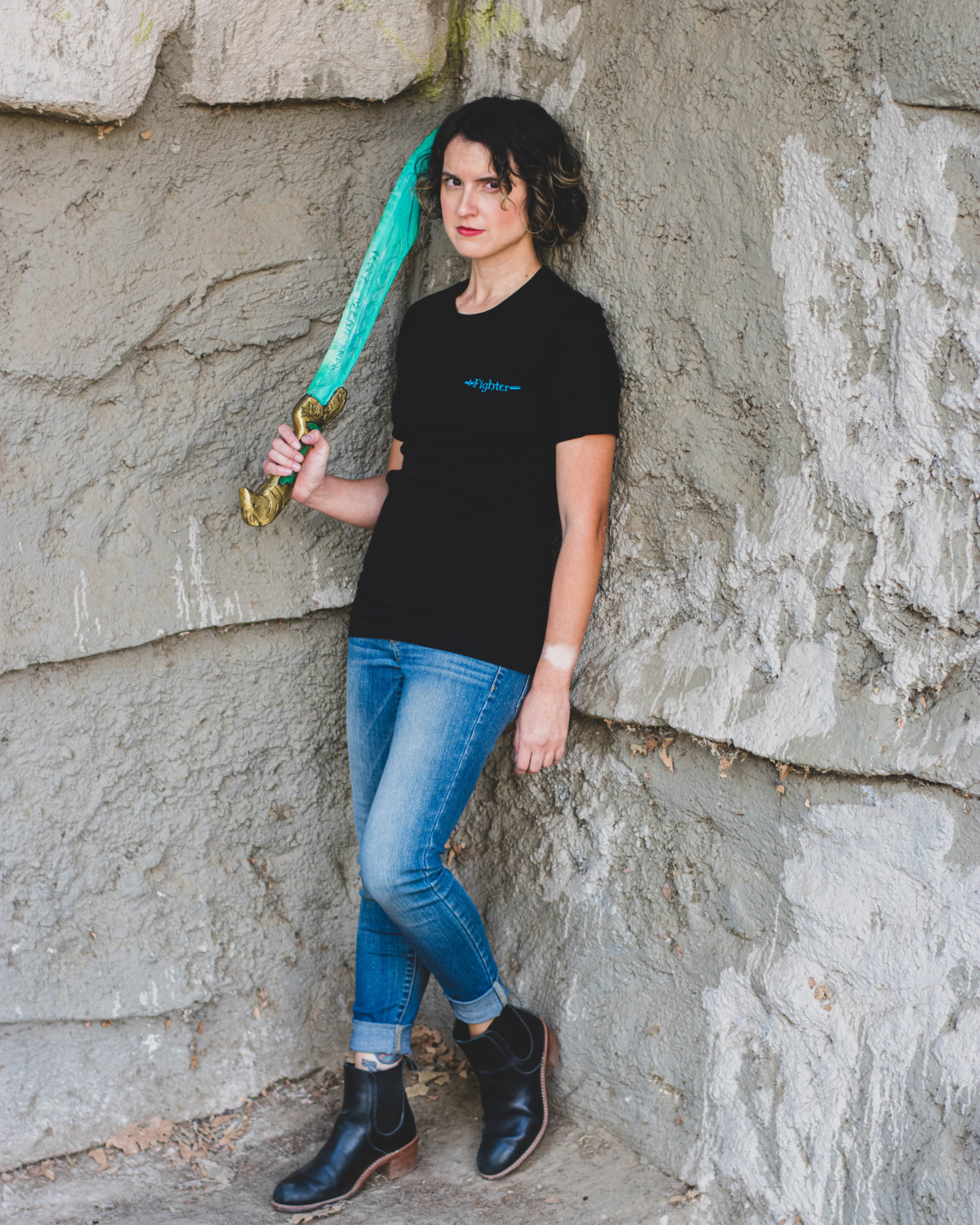 A model wields a sword and wears the black fighter tee from D&D fashion brand Guild Party.