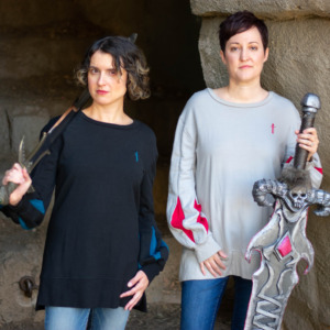 Two models hold swords while wearing pullovers from D&D fashion brand Guild Party.