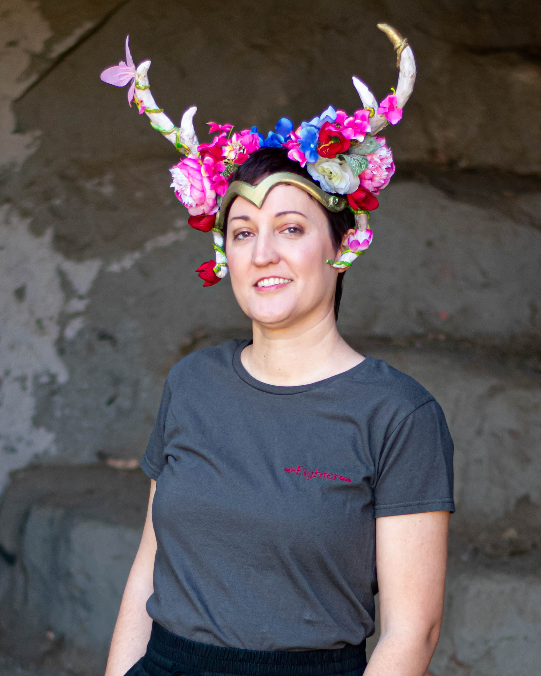 A model wears an elaborate headpiece with horns and flowers and a Fighter tee.