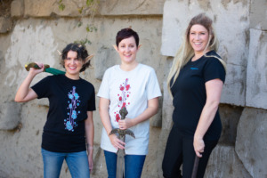 Three models wearing elf ears and carrying swords model t-shirts by D&D fashion brand Guild Party.