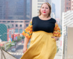 A model poses with a view of downtown LA, wearing a ruffle top inspired by Captain Marvel.