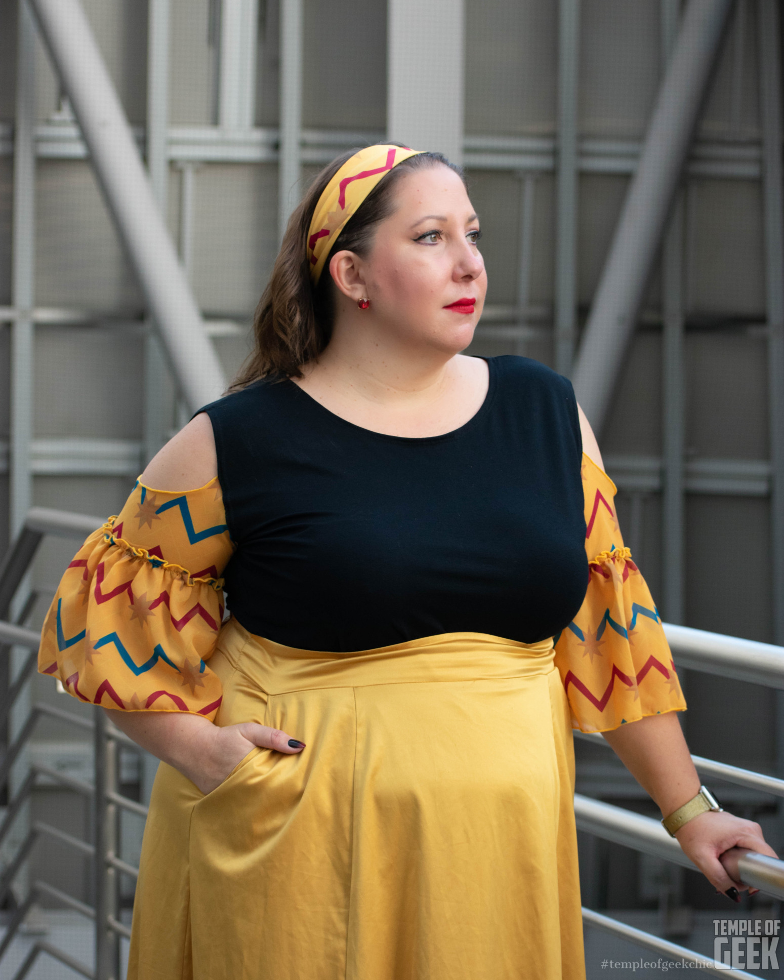 A model poses wearing a Captain Marvel themed ruffle sleeve top and headband.