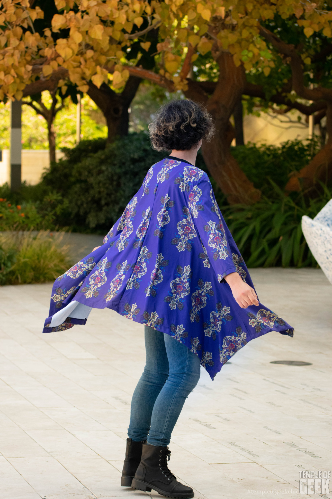 A model twirls while wearing a flowy cardigan featuring a Millennium Falcon print.