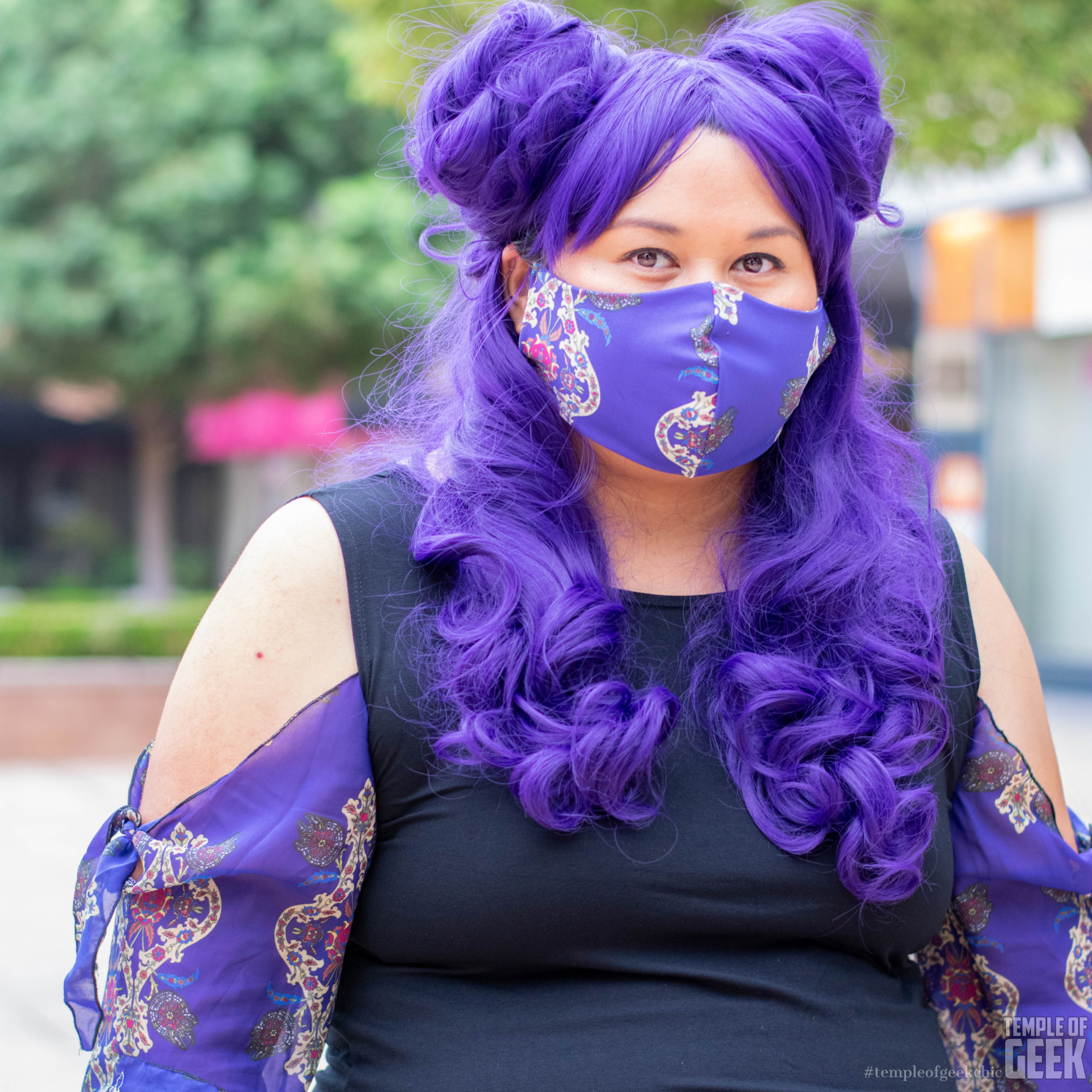 A model wears a purple wig and a face mask by Heroicouture.