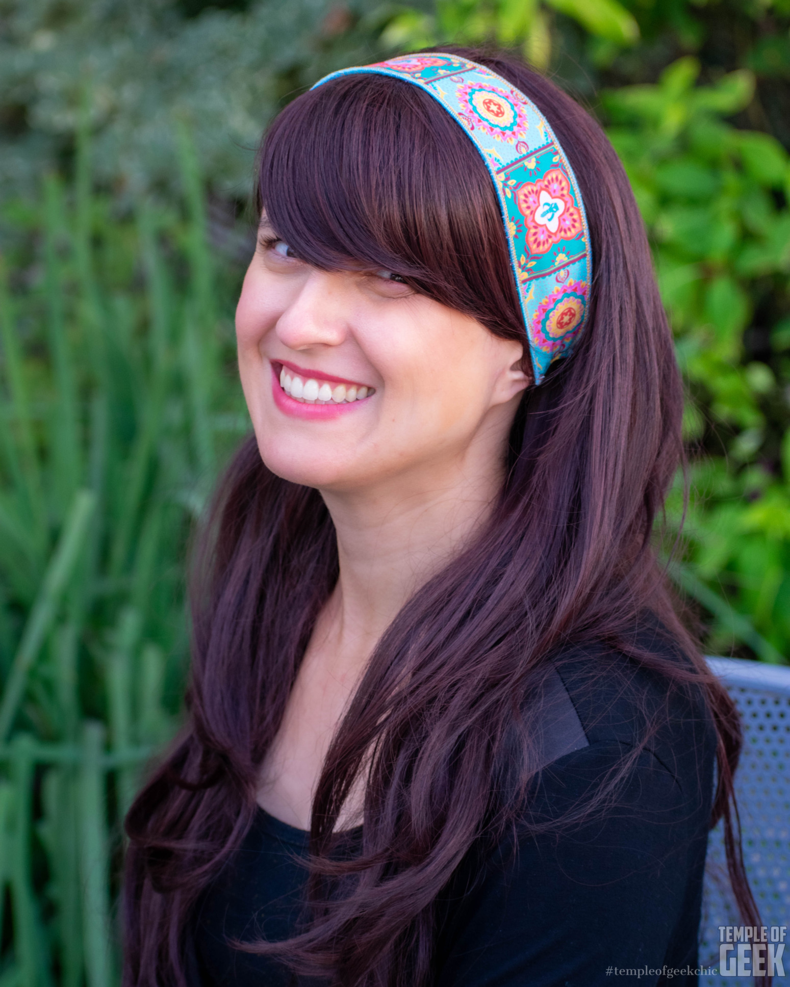 A smiling model wears a colorful headband.