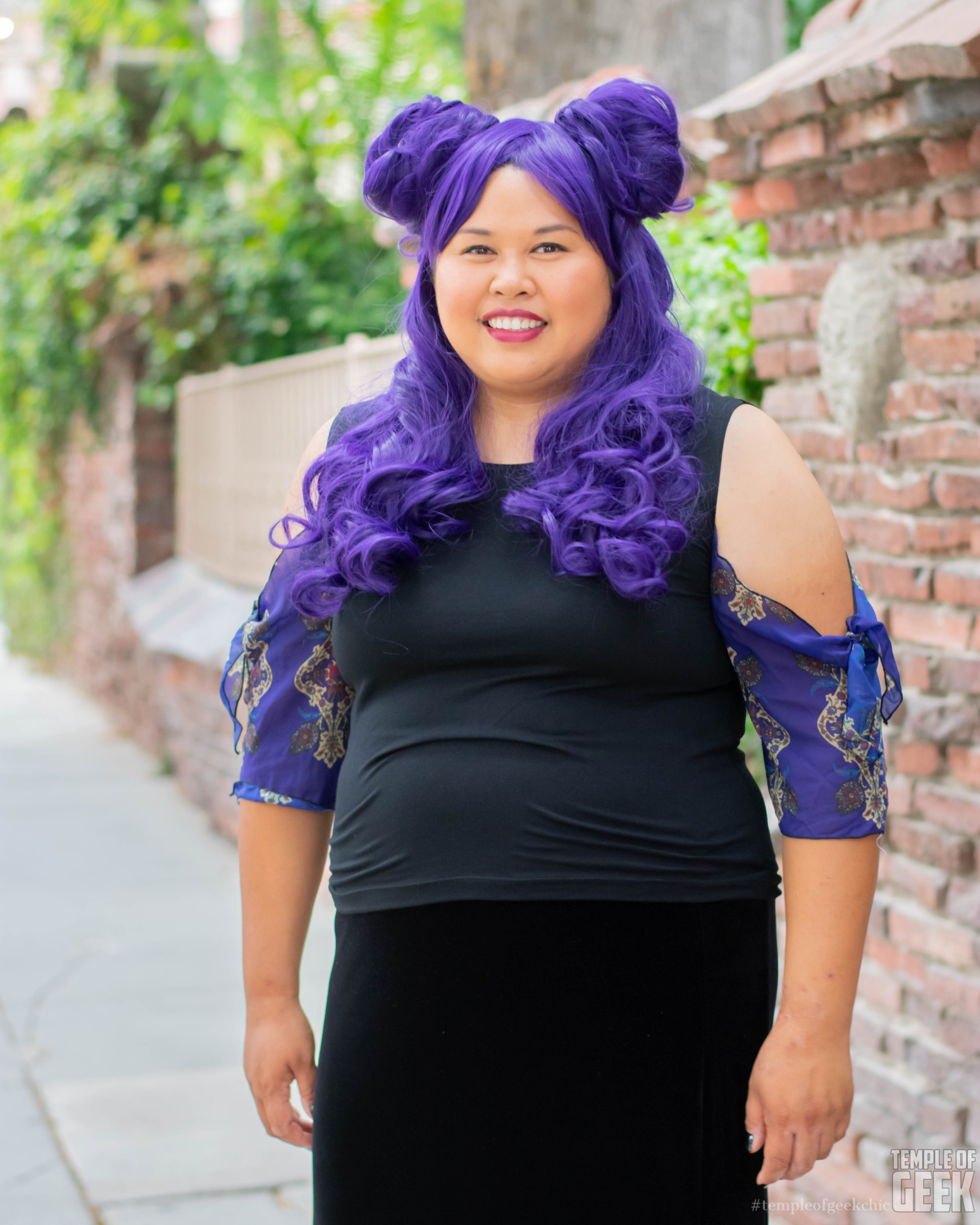 A model wears a purple wig and a tie sleeve top by Heroicouture.