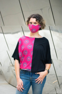 A model wears a dolman top and a face mask with a Wonder Woman's invisible jet theme at the Walt Disney Concert Hall. 