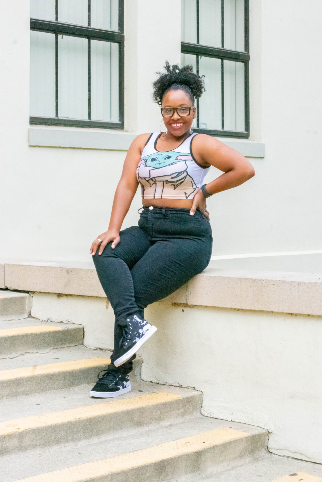 A model sits on a staircase wearing a Baby Yoda crop top.