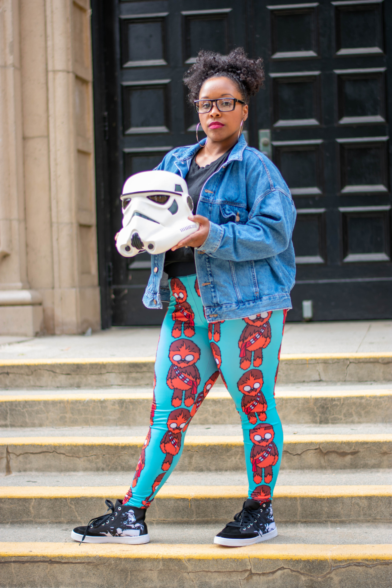 A model holds a Stormtrooper helmet and wears leggings with a Chewbacca print.