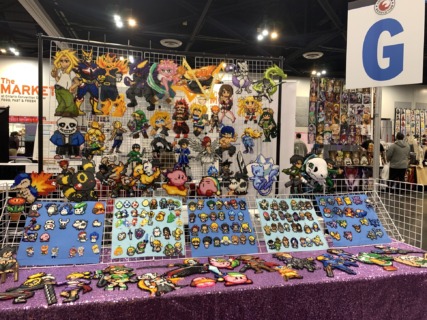 A vendor booth with artwork made with beads to resemble video game and anime characters