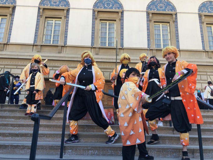 A group of Zenitsu cosplayers gather on the steps in front of the Pasadena Convention Center