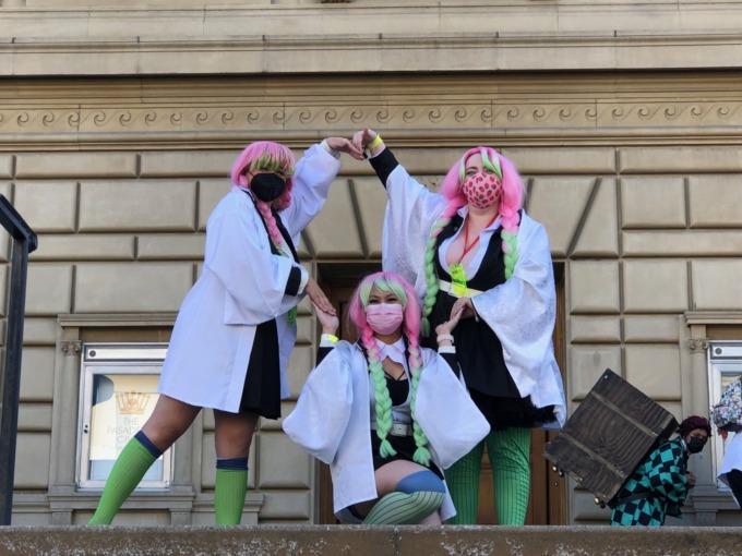 Mitsuri cosplayers pose for photos infron of the Pasadena Convention center. The join hand to form a circle