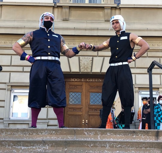 Two Tengen cosplayers gather on the steps of the Pasadena Convention center. They are fist bumping one another as they pose for photos