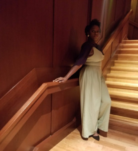 Arkeida Wilson shows off her fashion style on a dimly lit staircase. 