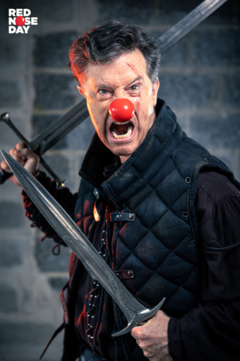 Stephen Colbert for Red Nose Day Holding Two Swords