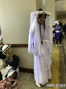 Xie Lian cosplayer dressed in white outfit against the wall at anime riverside