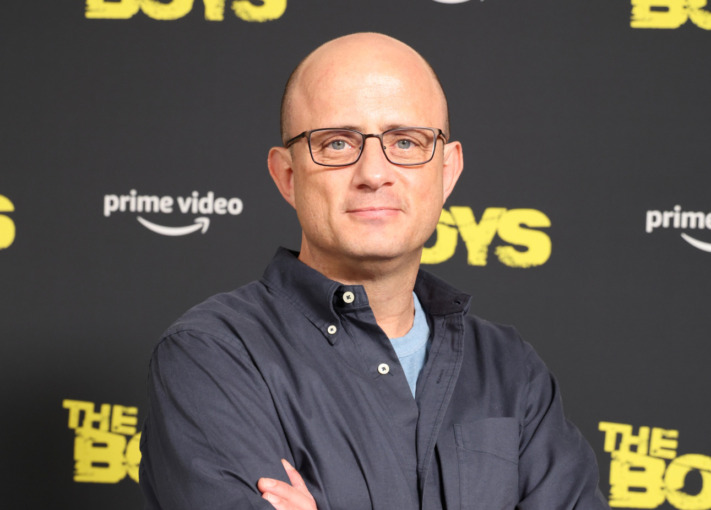 a man in glasses who has a shoved head at a press event