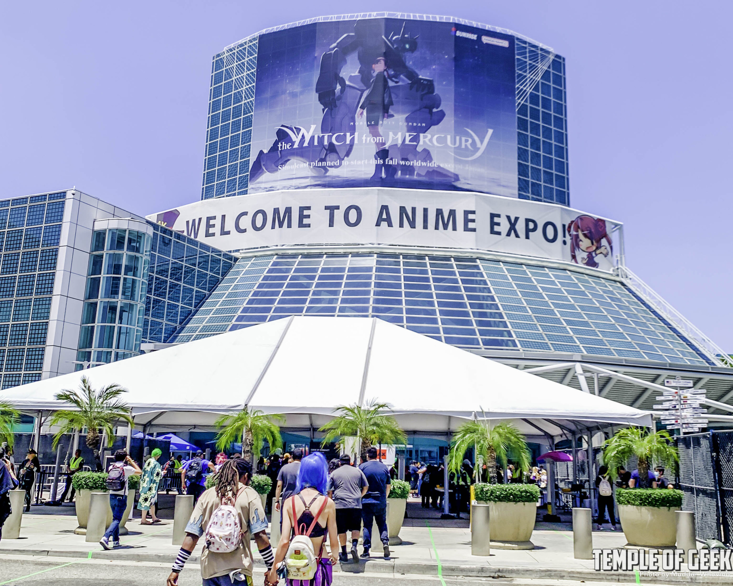 Outside view of people walking into the Los Angeles Convention Center for Anime Expo 2022. A banner across the front of the building reads "Welcome to Anime Expo"