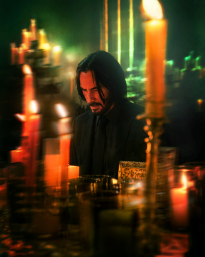 John Wick Chapter 4 Keyart with actor Keanu Reeves in looking contemplative surrounded by candles