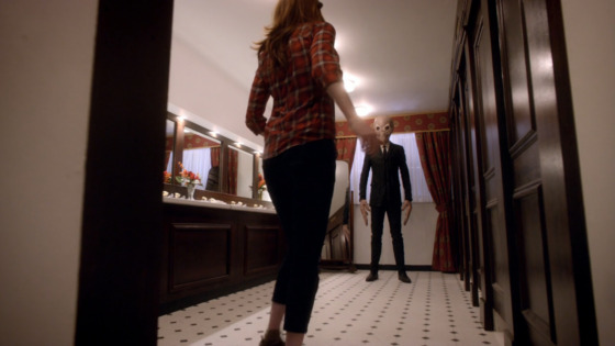 A screenshot from "The Impossible Astronaut", a shot of Amy Pond from behind as she encounters a Silence in the bathroom of the White House