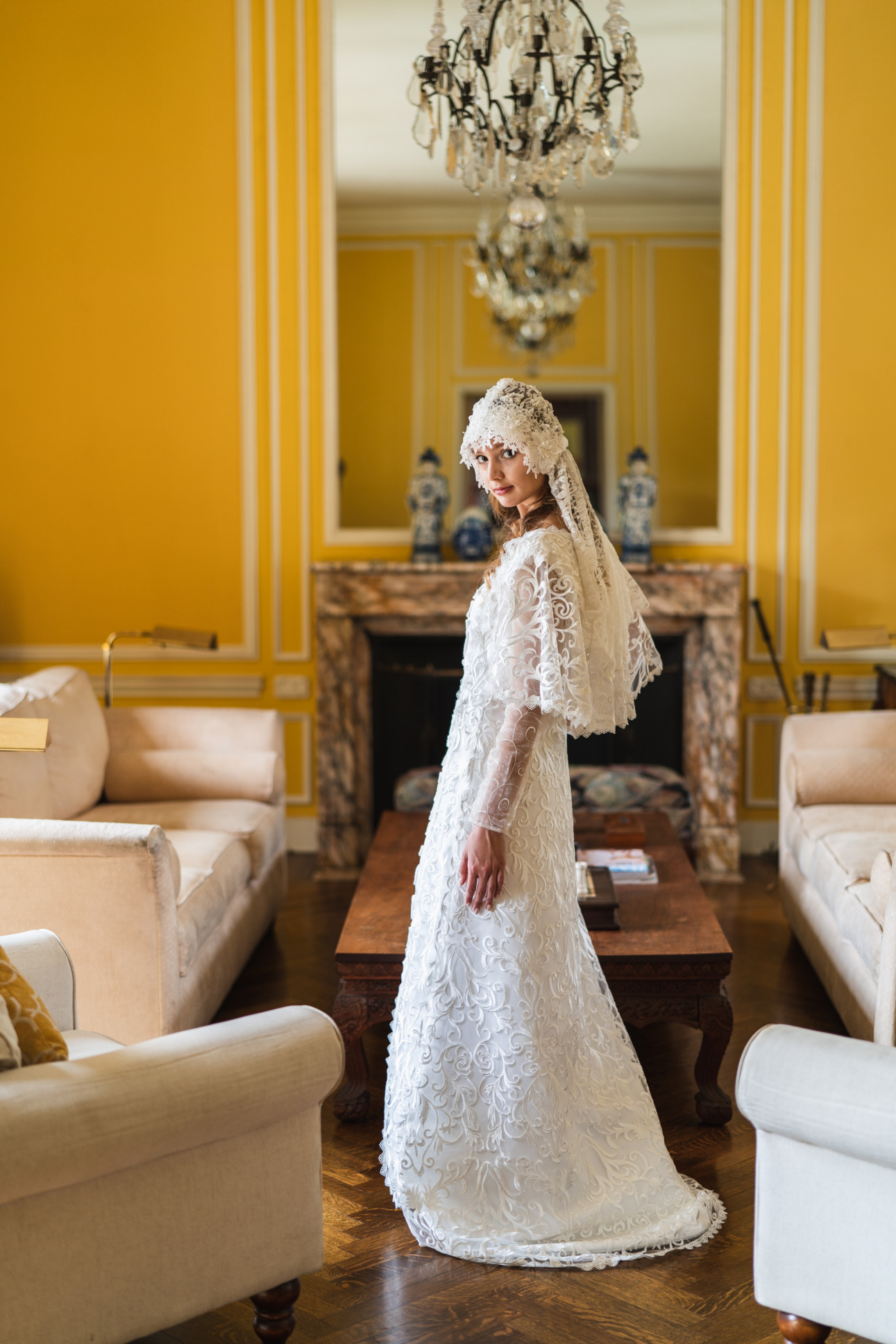 A model stands in the middle of a richly decorated room wearing a lacy white replica of a wedding dress from Star Wars.